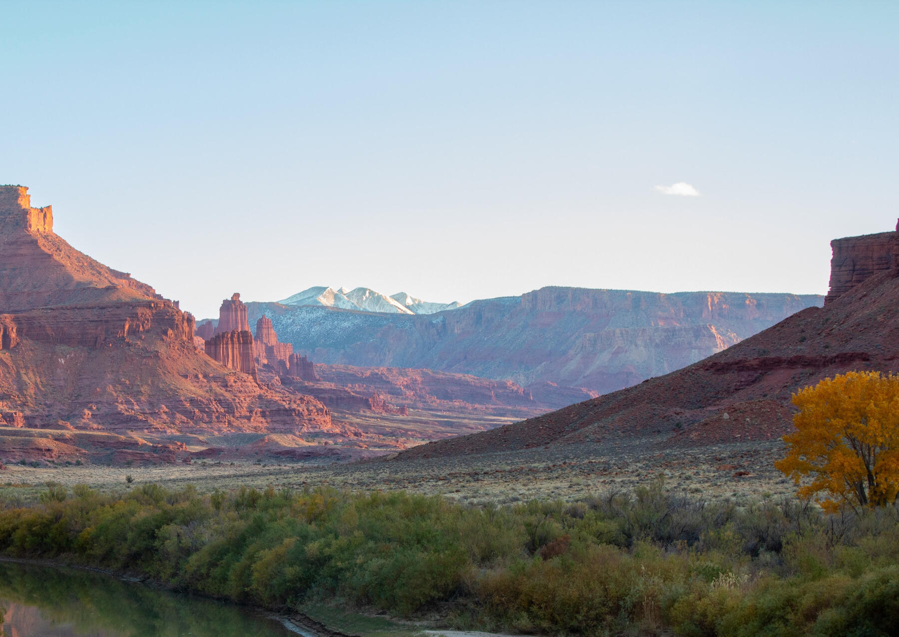 Moab landscape on highway 128 river in bottom corner Fisher Towers and red rocks in background with mountains behind all of that landscape Moab family wedding proposal photos photographer